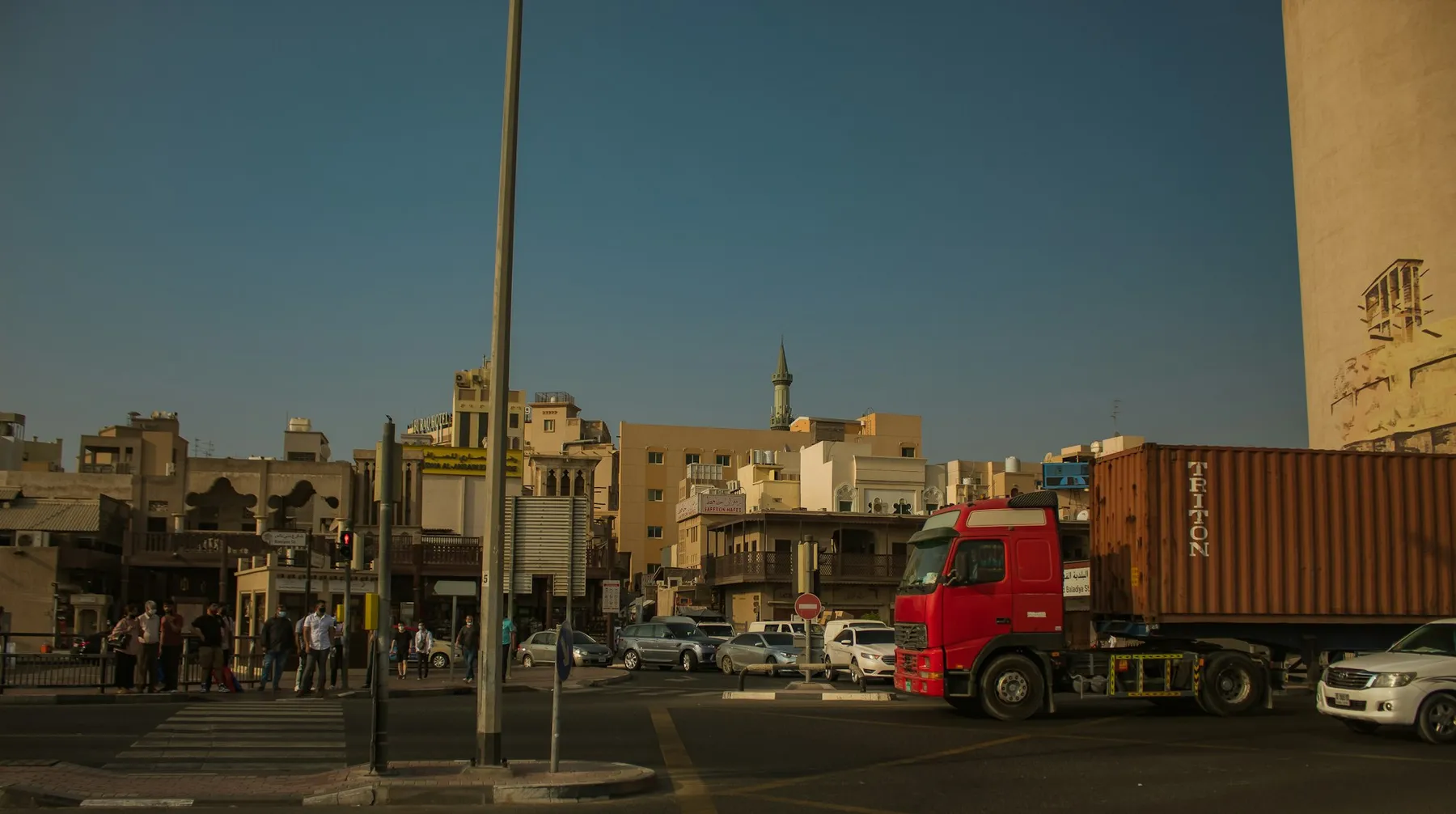 Red truck carrying a shipping container through a city street